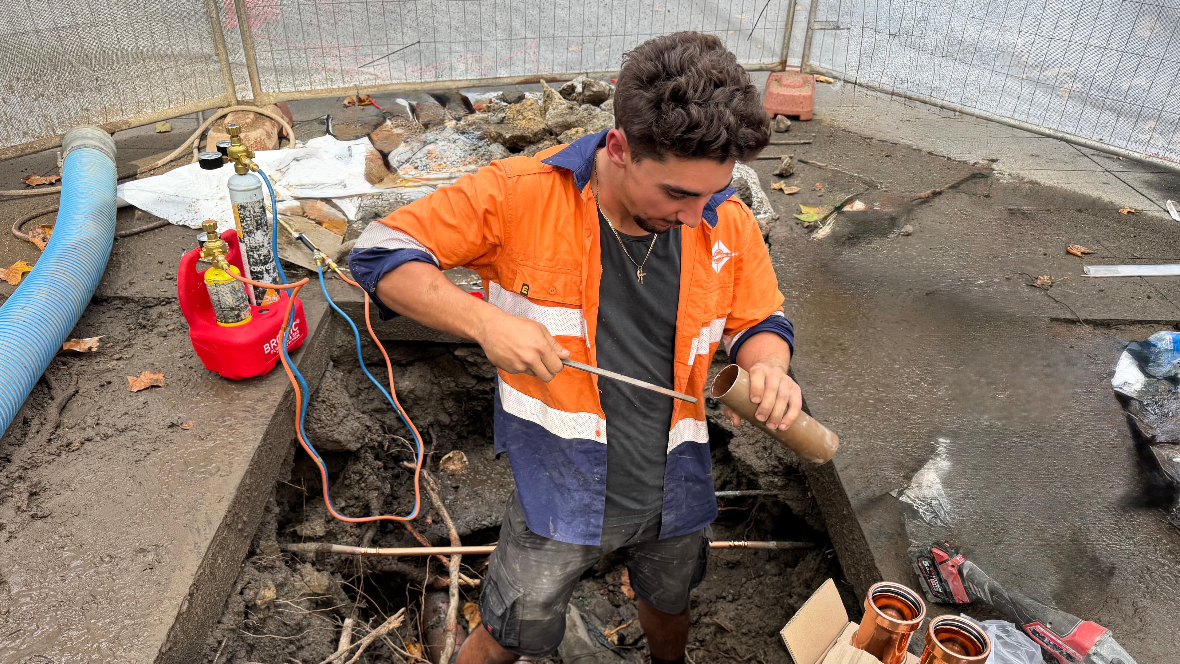 On-site repair work — Combined Commercial tradesperson preparing copper fittings.